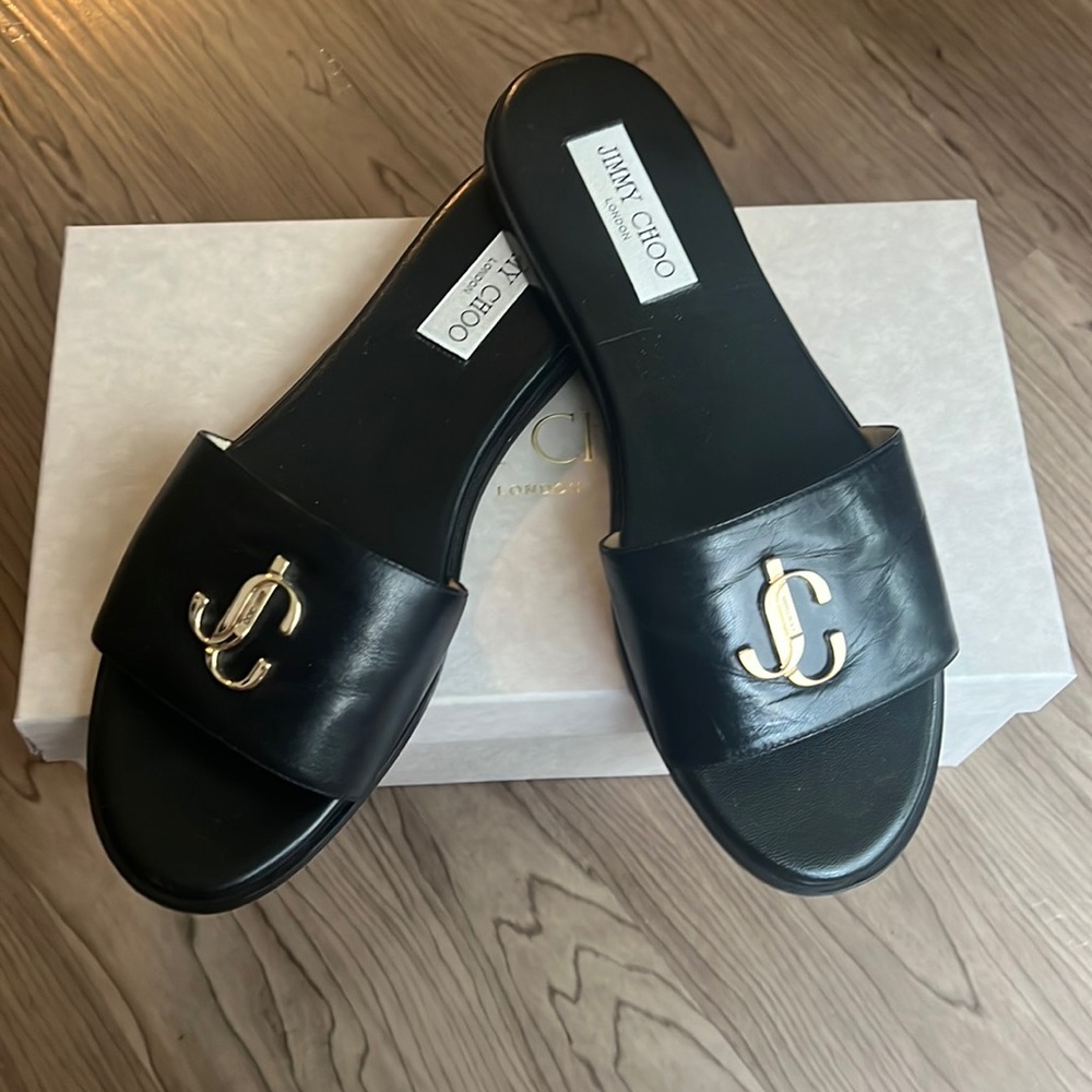 Jummy Choo leather black slides with gold tone logo.